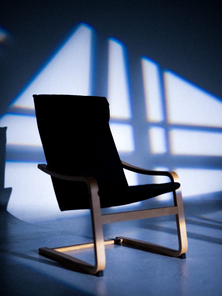 photography studio space with one chair. there are shadows on the wall